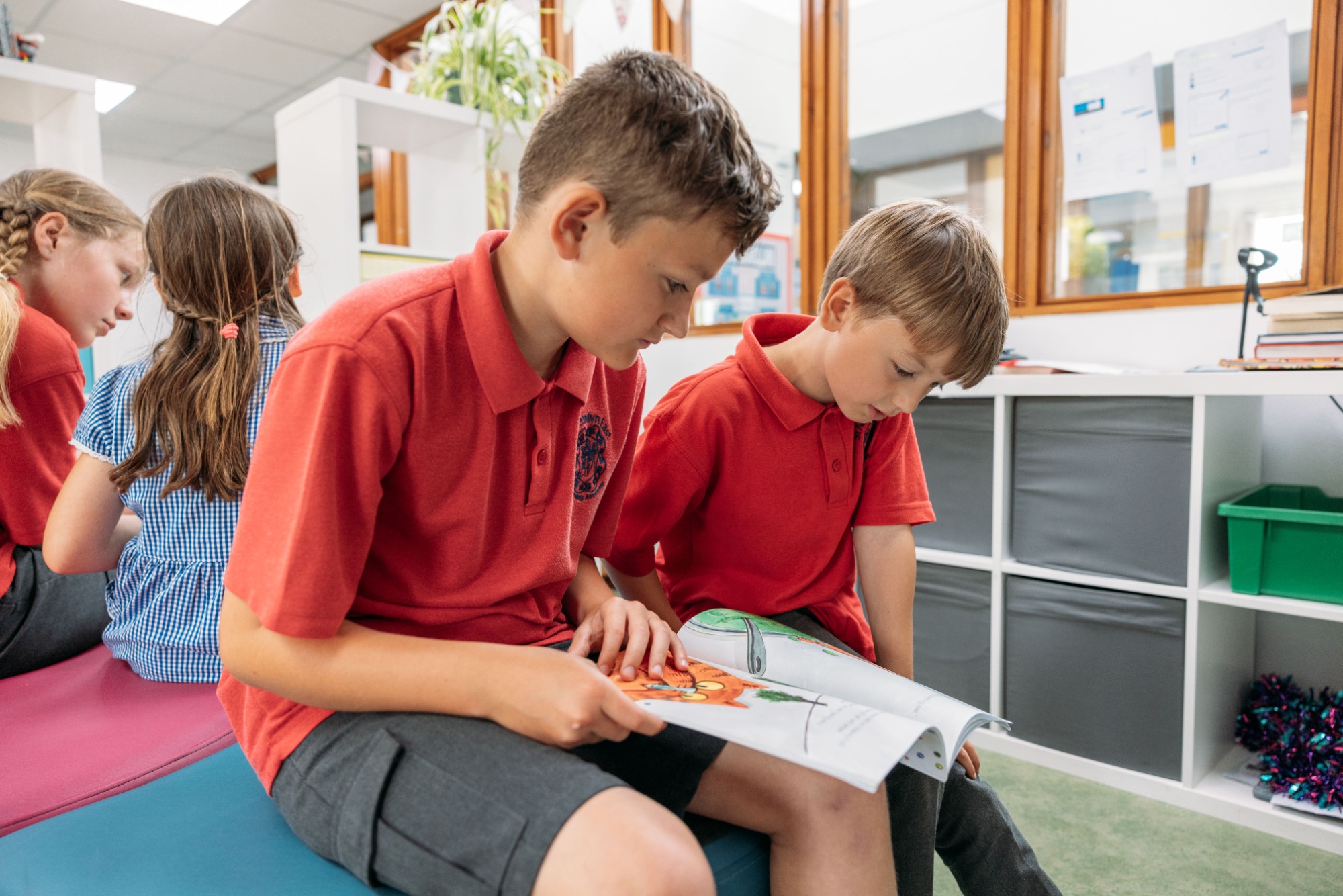 Children sat in the library enjoying reading books